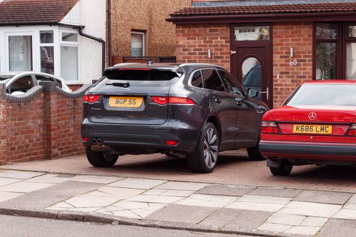 Two cars parked in UK driveway. Two-car households are increasing.